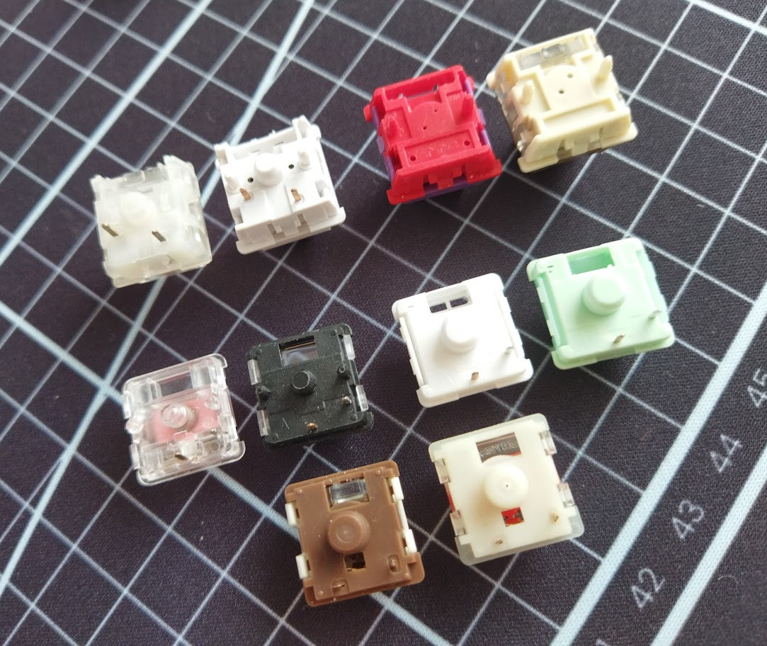 Pic: There are all kinds of incompatible switches out there. MX (tl), Hall-effect (tr), Choc V1 (ml), Choc V2 (mr), Gateron LP (bottom)